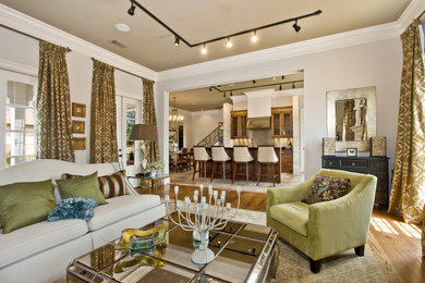Example of a trendy medium tone wood floor living room design in New Orleans with white walls