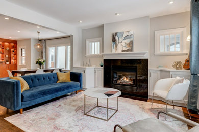 Living room - traditional open concept medium tone wood floor and beige floor living room idea in Calgary with white walls, a standard fireplace, a tile fireplace and no tv