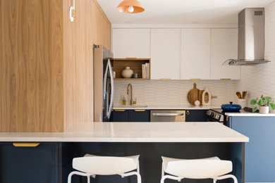 Inspiration for a small modern u-shaped porcelain tile and gray floor enclosed kitchen remodel in Montreal with an undermount sink, flat-panel cabinets, blue cabinets, quartz countertops, white backsplash, ceramic backsplash, stainless steel appliances, a peninsula and white countertops