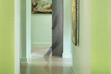 Design ideas for a mid-sized contemporary hallway in Los Angeles with green walls and light hardwood floors.