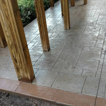 J-Stamped concrete patio with a step under the wood deck