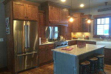 Eat-in kitchen - shabby-chic style u-shaped medium tone wood floor eat-in kitchen idea in Other with a farmhouse sink, granite countertops, stainless steel appliances, an island, shaker cabinets, medium tone wood cabinets, beige backsplash and matchstick tile backsplash