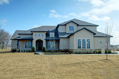 Example of a large beige two-story exterior home design in Other