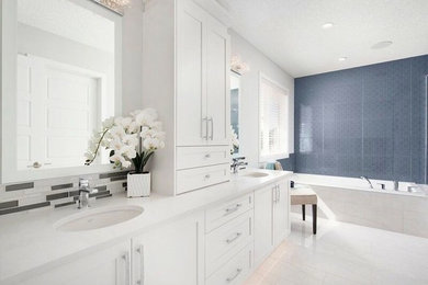 Bathroom - large transitional master gray tile, white tile and matchstick tile porcelain tile and beige floor bathroom idea in Calgary with shaker cabinets, white cabinets, white walls, an undermount sink and solid surface countertops