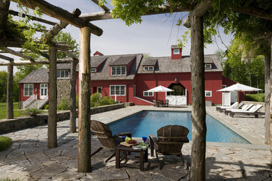 Expansive country side yard rectangular pool in New York with natural stone pavers.