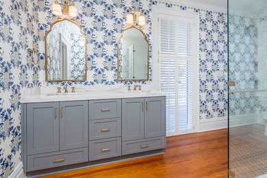 Inspiration for a mid-sized transitional master medium tone wood floor corner shower remodel in Atlanta with shaker cabinets, gray cabinets, an undermount sink, quartz countertops, blue walls and a one-piece toilet