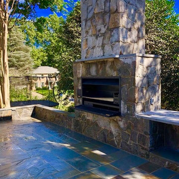 Outdoor Stone Fireplace with Braai grill, counter tops, and seating areas