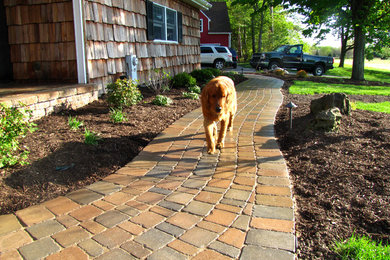 This is an example of a mid-sized transitional partial sun front yard brick landscaping in New York for summer.