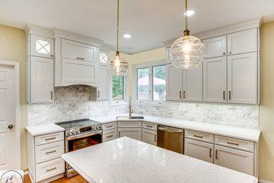Example of a large transitional light wood floor and brown floor eat-in kitchen design in DC Metro with an undermount sink, shaker cabinets, white cabinets, quartz countertops, gray backsplash, marble backsplash, stainless steel appliances, an island and white countertops