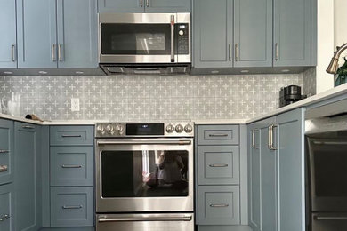 Small transitional u-shaped medium tone wood floor open concept kitchen photo in Vancouver with an undermount sink, shaker cabinets, blue cabinets, quartz countertops, gray backsplash, porcelain backsplash, stainless steel appliances, a peninsula and white countertops