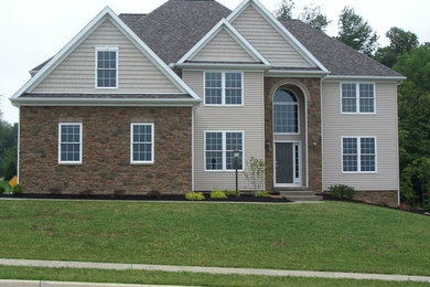 Large traditional two-story brick exterior home idea in Cleveland