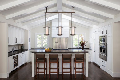 This is an example of a transitional u-shaped kitchen in San Francisco with shaker cabinets, white cabinets, stainless steel appliances, dark hardwood floors and with island.