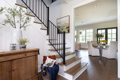 Example of a classic medium tone wood floor, brown floor and shiplap wall foyer design in Little Rock with white walls
