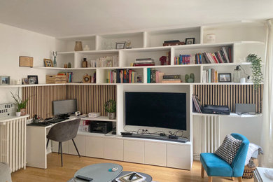 Ejemplo de sala de estar con biblioteca abierta escandinava grande con paredes blancas, suelo de madera clara y televisor independiente