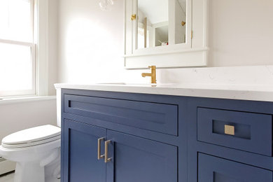 Mid-sized arts and crafts kids' white tile and subway tile porcelain tile, white floor and single-sink bathroom photo in Chicago with shaker cabinets, blue cabinets, a two-piece toilet, white walls, an undermount sink, quartz countertops, white countertops, a niche and a built-in vanity