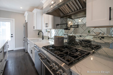 Inspiration for a mid-sized transitional single-wall dark wood floor and brown floor eat-in kitchen remodel in Boston with a farmhouse sink, shaker cabinets, white cabinets, quartzite countertops, glass tile backsplash, stainless steel appliances and an island