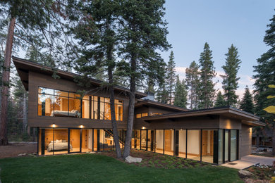 Large minimalist brown two-story wood and board and batten house exterior photo in San Francisco with a black roof, a shed roof and a mixed material roof