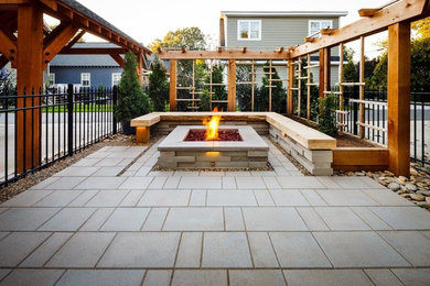 Arts and crafts backyard patio in Charlotte with a fire feature, concrete pavers and a pergola.
