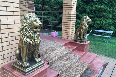 Скульптуры бетонных львов в золотом цвете на главной лестнице