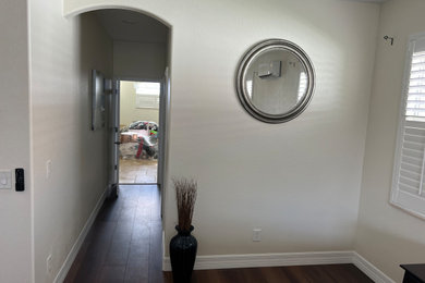 Imagen de recibidores y pasillos minimalistas pequeños con paredes beige, suelo vinílico y suelo marrón