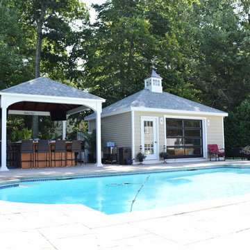Pool house featuring a french door, glass design, hip roof, and a cupola.