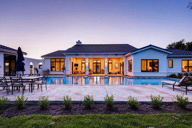 Example of a large trendy white two-story house exterior design in Austin with a tile roof