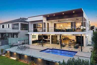 Large modern two-storey concrete white house exterior in Gold Coast - Tweed with a flat roof and a metal roof.