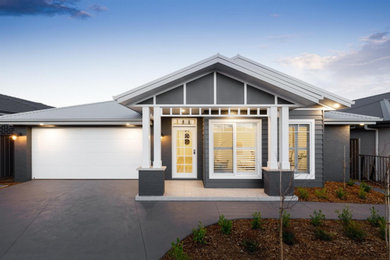 Photo of a mid-sized beach style one-storey grey house exterior in Wollongong with a gable roof, a metal roof and a grey roof.