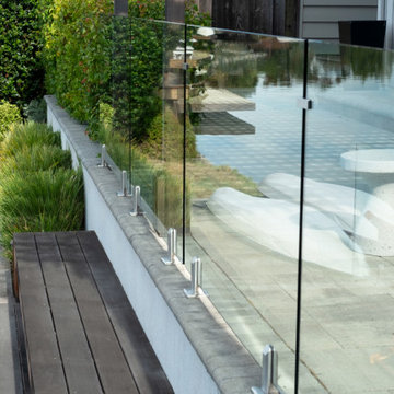 Glass safety railing separating patio level from sun deck