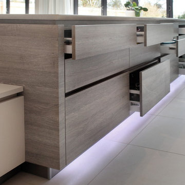 Handleless matt cashmere & grey wood effect kitchen with variety of storage