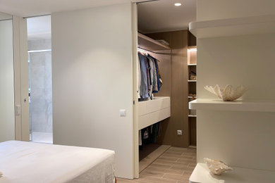Diseño de armario y vestidor unisex minimalista de tamaño medio con a medida, armarios abiertos, puertas de armario de madera clara y suelo de madera clara