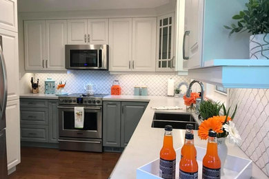 Transitional u-shaped medium tone wood floor eat-in kitchen photo in Toronto with an undermount sink, raised-panel cabinets, white cabinets, quartz countertops, white backsplash, porcelain backsplash, stainless steel appliances, no island and white countertops