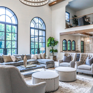 Großes, Offenes Mediterranes Wohnzimmer mit beiger Wandfarbe, Keramikboden, Tunnelkamin, Kaminsims aus Stein, Wand-TV und braunem Boden in Salt Lake City