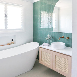 Photo of a mid-sized beach style master bathroom in Other with light wood cabinets, a freestanding tub, an open shower, multi-coloured tile, ceramic tile, multi-coloured walls, porcelain floors, a vessel sink, solid surface benchtops, white floor, an open shower, white benchtops, a niche, a single vanity and a floating vanity.