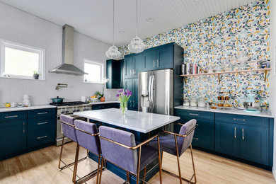 Open concept kitchen - transitional l-shaped medium tone wood floor, brown floor and shiplap ceiling open concept kitchen idea in Austin with shaker cabinets, blue cabinets, multicolored backsplash, stainless steel appliances, an island and gray countertops