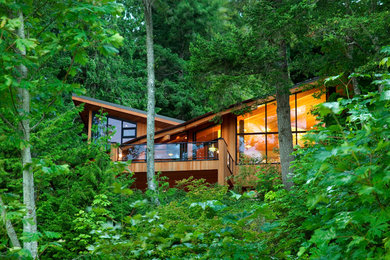 Mid-sized trendy brown two-story mixed siding house exterior photo in Seattle with a shed roof