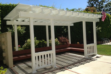 Photo of a mid-sized traditional backyard patio in Los Angeles with concrete pavers.