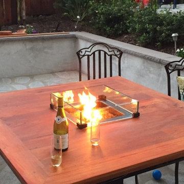 Outdoor dining table with glass enclosed fire pit