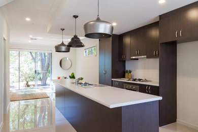 Photo of a contemporary eat-in kitchen in Adelaide with a double-bowl sink, dark wood cabinets, laminate benchtops, beige splashback, ceramic splashback, stainless steel appliances, ceramic floors and with island.