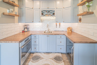 Inspiration for a small craftsman u-shaped vinyl floor and brown floor wet bar remodel in St Louis with a drop-in sink, shaker cabinets, gray cabinets and wood countertops