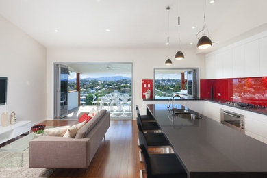 Photo of a mid-sized contemporary living room in Brisbane with white walls and a wall-mounted tv.