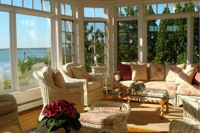 Inspiration for a mid-sized timeless light wood floor family room remodel in New York with white walls and no fireplace