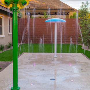 Großer Stilmix Garten im Sommer, hinter dem Haus mit Wasserspiel und Betonplatten in Las Vegas
