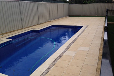 Design ideas for a mid-sized contemporary backyard rectangular lap pool in Melbourne with a water feature and concrete pavers.