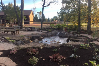 Photo of a large farmhouse shade front yard stone pond in Philadelphia.