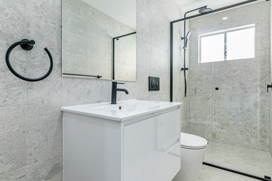 Photo of a small contemporary master bathroom in Sydney with white cabinets, a one-piece toilet, gray tile, porcelain tile, porcelain floors, grey floor, white benchtops, an enclosed toilet, a single vanity and a floating vanity.