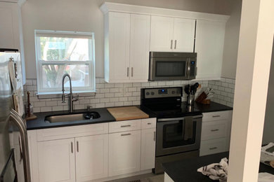 Shaker White Cabinets with Black Pearl Granite, and White subway tile