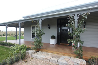 Inspiration for a large traditional front yard verandah in Other with decking and a roof extension.