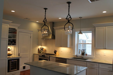 Eat-in kitchen - eclectic single-wall medium tone wood floor eat-in kitchen idea in Boston with an undermount sink, white backsplash, ceramic backsplash, stainless steel appliances and an island