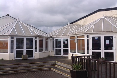 Design ideas for a gey contemporary glass house exterior in Cheshire with a hip roof.